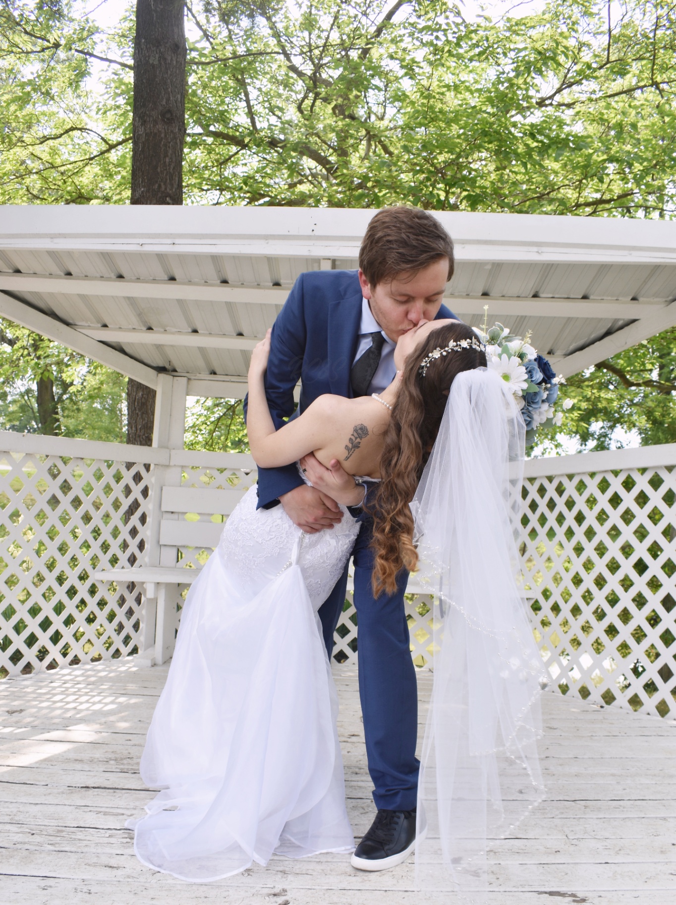 Bride and groom dip kiss at a gazebo